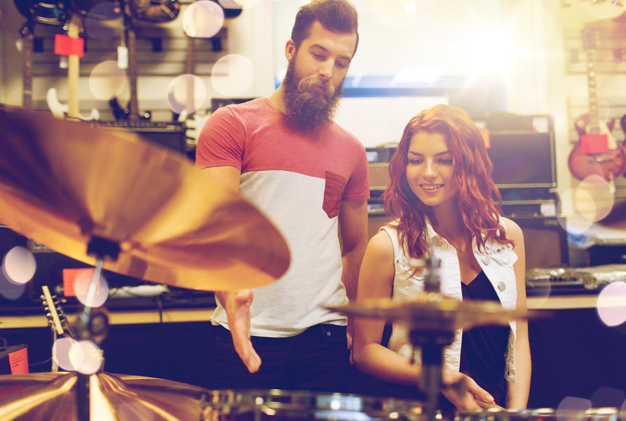 sale people musical instruments entertainment concept happy couple musicians with drum kit music sto